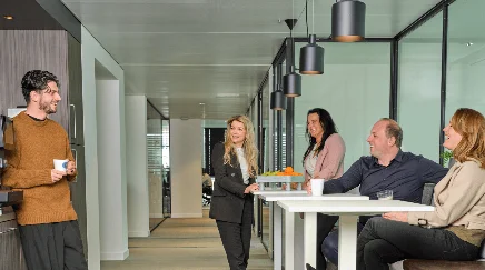 Collega's in gesprek bij de koffiecorner